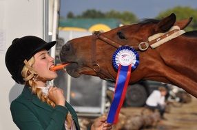 young girl feeding a horse with a carrot