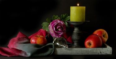 apples, flowers and a candle set for still life