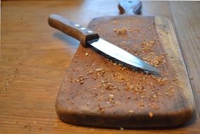 knife and cutting board with bread crumbs