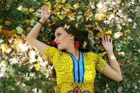 girl in colorful clothing on a background of of autumn leaves