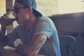 guy man glasses tattoos tshirt drink breakfast