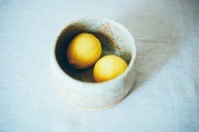 two small lemons in a stone bowl