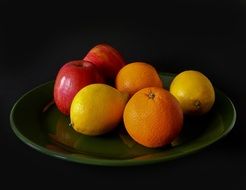 fruits containing vitamin c on a green plate