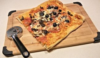 square pizza with salami, mushrooms, olives, and cheese