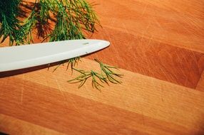 knife cutting herbs on board