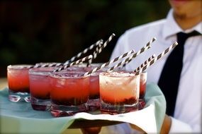 waiter brining cold cocktails for guests in the party