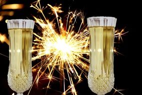 champagne glasses filled with sparkling wine on the background of sparklers