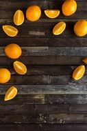 slices of oranges and full oranges on a wooden table