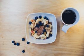 bowl of fruit salad and coffee on the breakfast table