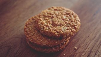 three delicious cookies are on a wooden table