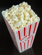 paper bag with popcorn on a black background