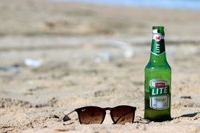 sun glasses and beer on the sand