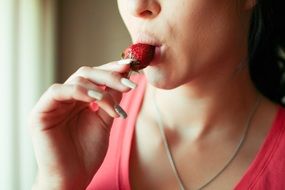 girl holding strawberries on her hand