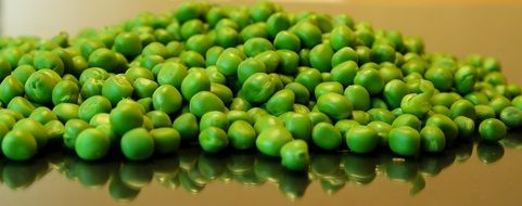 green peas on mirroring surface
