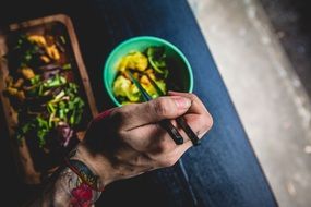 closeup photo of eating asian food with a chop sticks