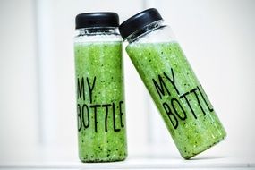 green smoothie in transparent bottles