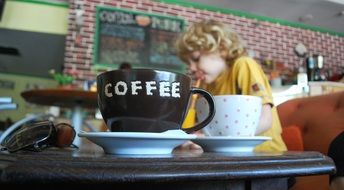 hot drinks in the family cafe with child on background