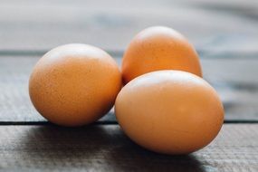 three eggs on a wooden table