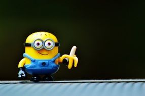 Cute funny minion with banana at dark background