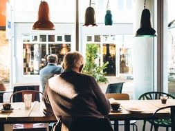 men are sitting in a coffee shop