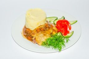 a dish of chicken and potatoes decorated with vegetables