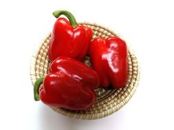 Three red paprikas in a basket