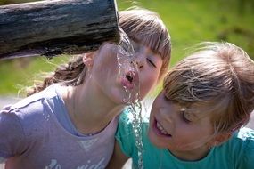 Two blonde girls driking water