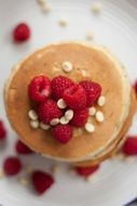 Raspberries on a pancakes on the white plate