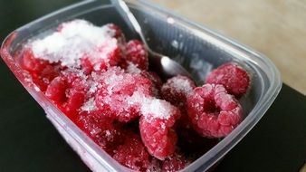 frozen raspberries in a plastic container