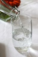 water is poured into a glass from a bottle
