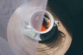 white cup of tea half closed with curtain