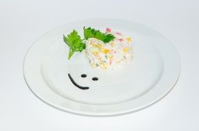 useful salad on a white plate beautified smiley of sauce