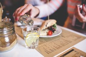 glass of water with lemon on a table in a cafe