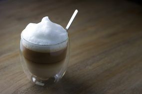 foamy latte coffee in glass cup