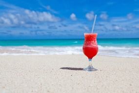 Photo of cocktail is on a sandy beach