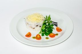 salad on a white plate decorated with tomatoes and sauce