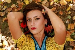portrait of girls face with a penetrating look at the background of autumn leaves