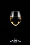 glass with white wine at black background