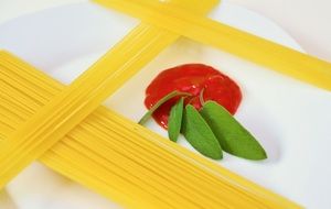 spaghetti with red sauce and green leaves