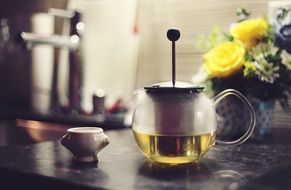 green tea in a glass teapot on the table