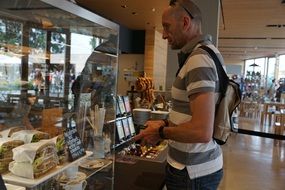 adult man buying food in cafe