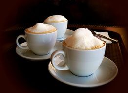 three cups of cappuccino on a tray