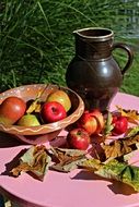 table decoration with apples, fall foliage and jug