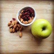 apple near a glass with nuts