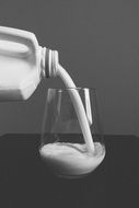 pouring milk into the glass, black and white