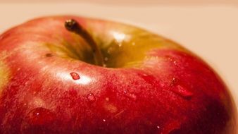 red apple in drops of water close up