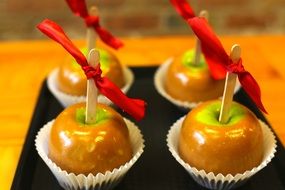 sweet caramel apples on wand with red ribbon