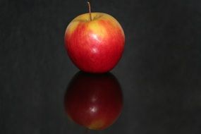 The red apple on the black glace table