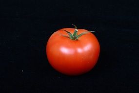 red tomato on a black background