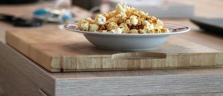 popcorn on a plate on a wooden board